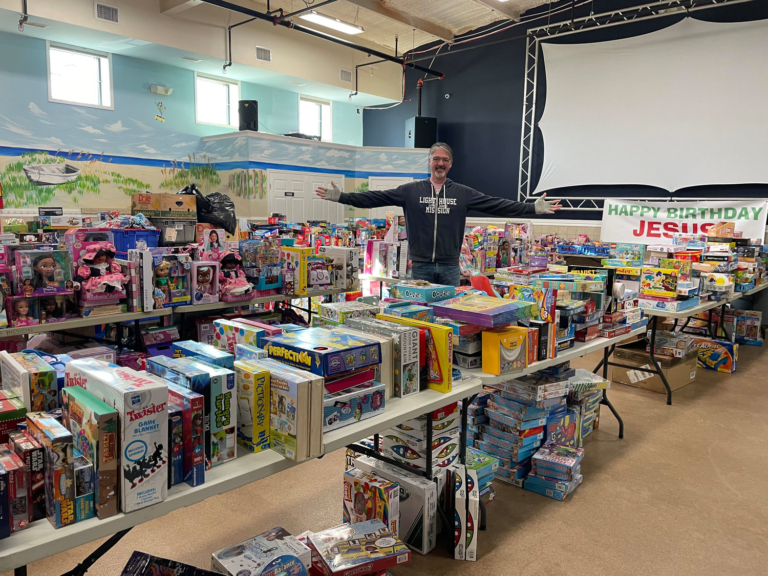 Pastor Jim Ryan stands with the hundreds of toys and other items, which were handed out to the community right before Christmas.